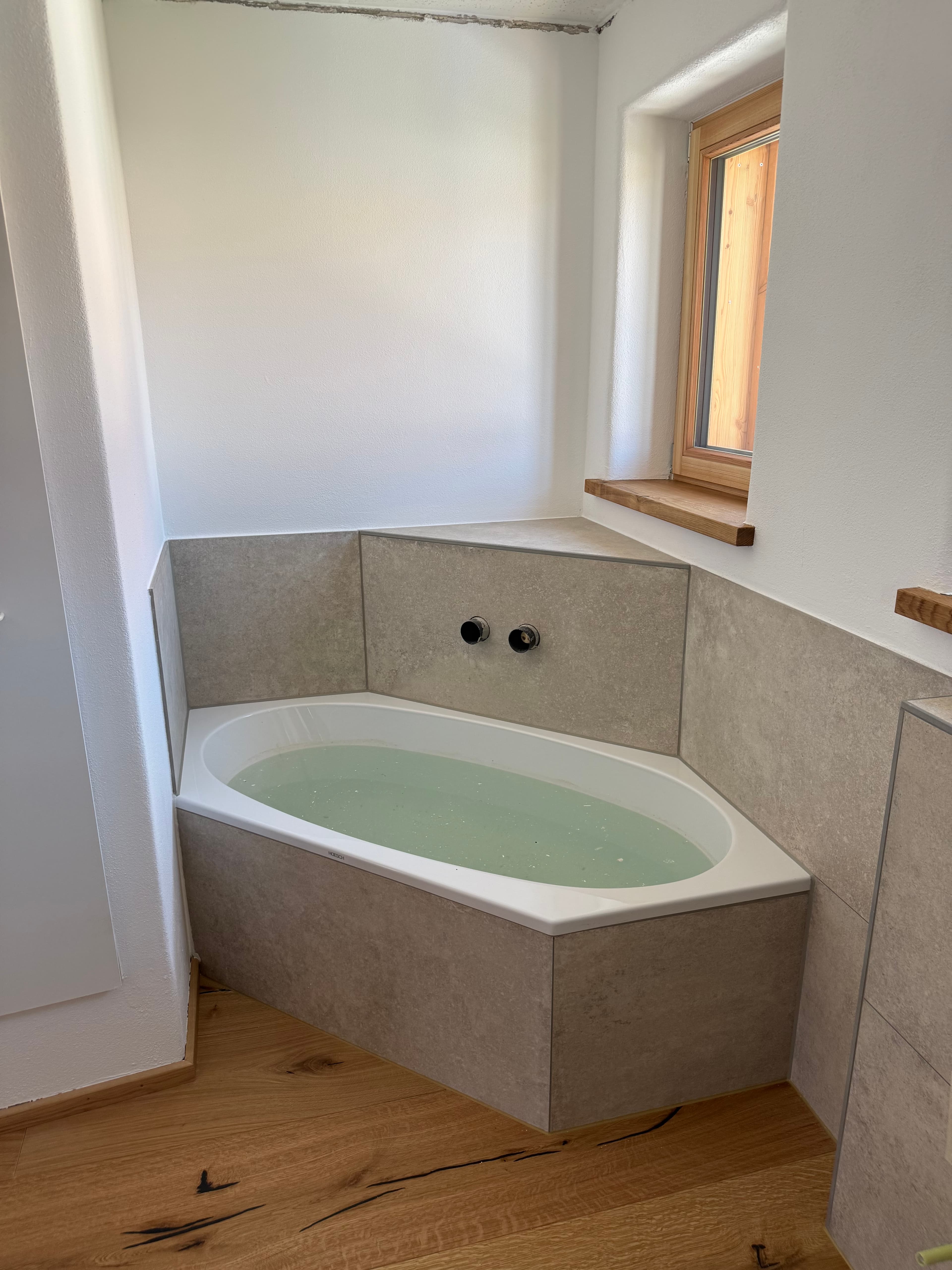Badewanne mit Steinoptik und sauberen Anschlüssen